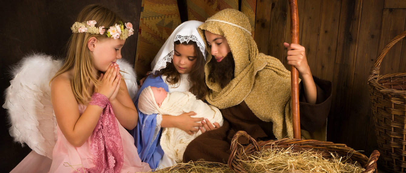 Kinder sind als Maria, Josef, Jesuskind und Engel verkleidet