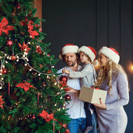 Ideen für ein sinnerfülltes Weihnachten - meinefamilie.at  Familie schmückt Weihnachtsbaum