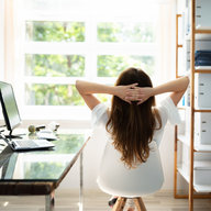 Frau scheut bei der Arbeit entspannt aus dem Fenster
