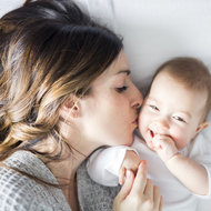 Mutter küsst ihr Baby auf die Wange