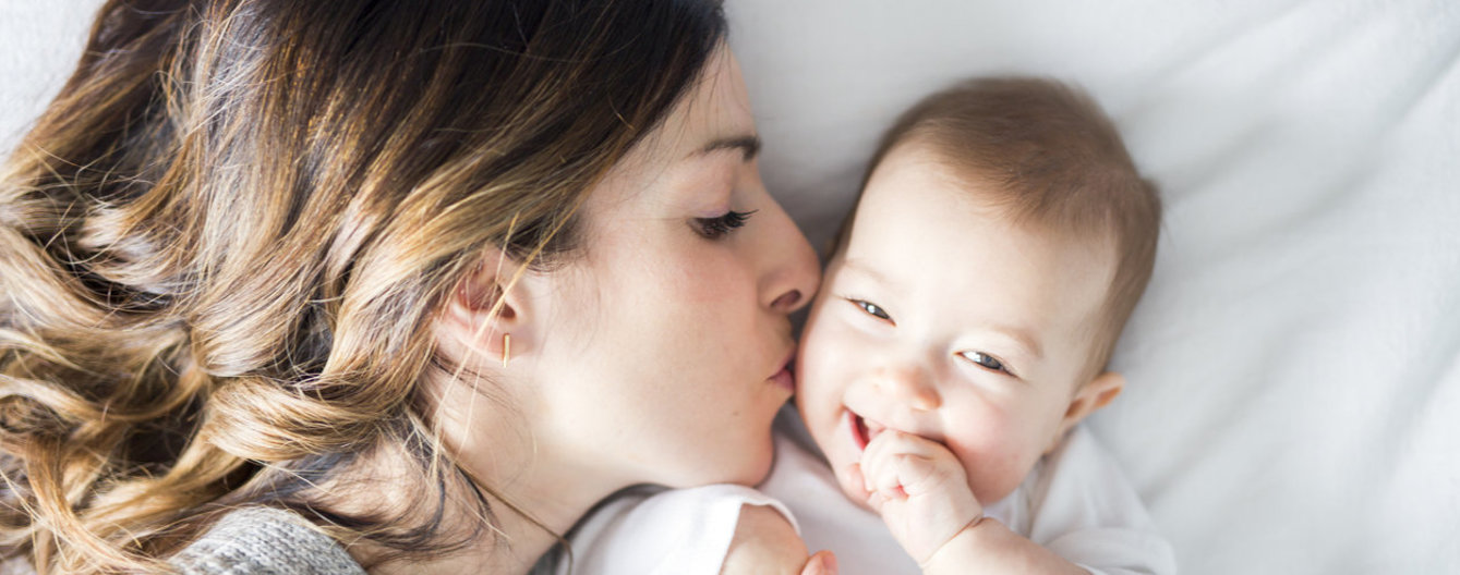 Mutter küsst ihr Baby auf die Wange