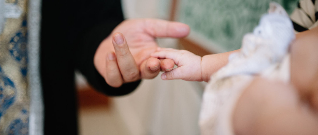 Babyhand und Priesterhand