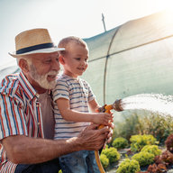 Opa gießt mit Enkerl den Garten