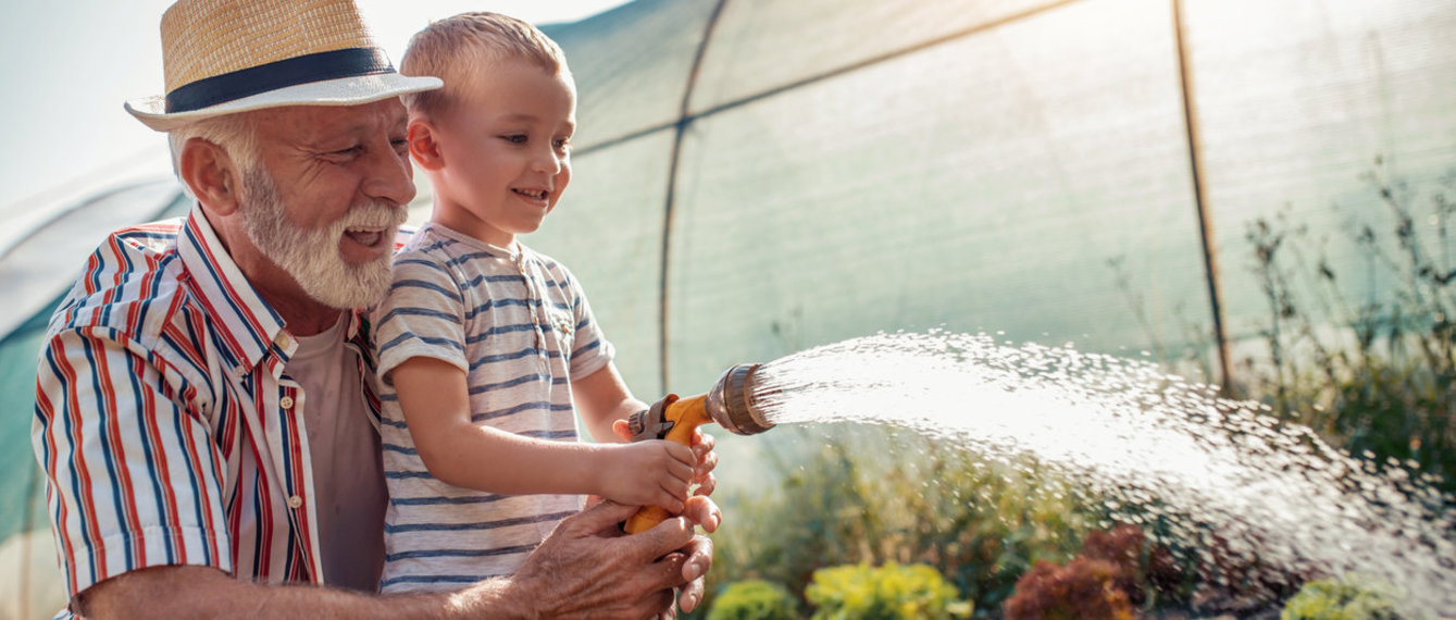 Opa gießt mit Enkerl den Garten