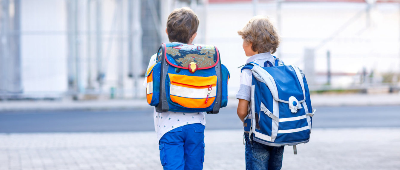 Zwei Schüler mit Schultaschen