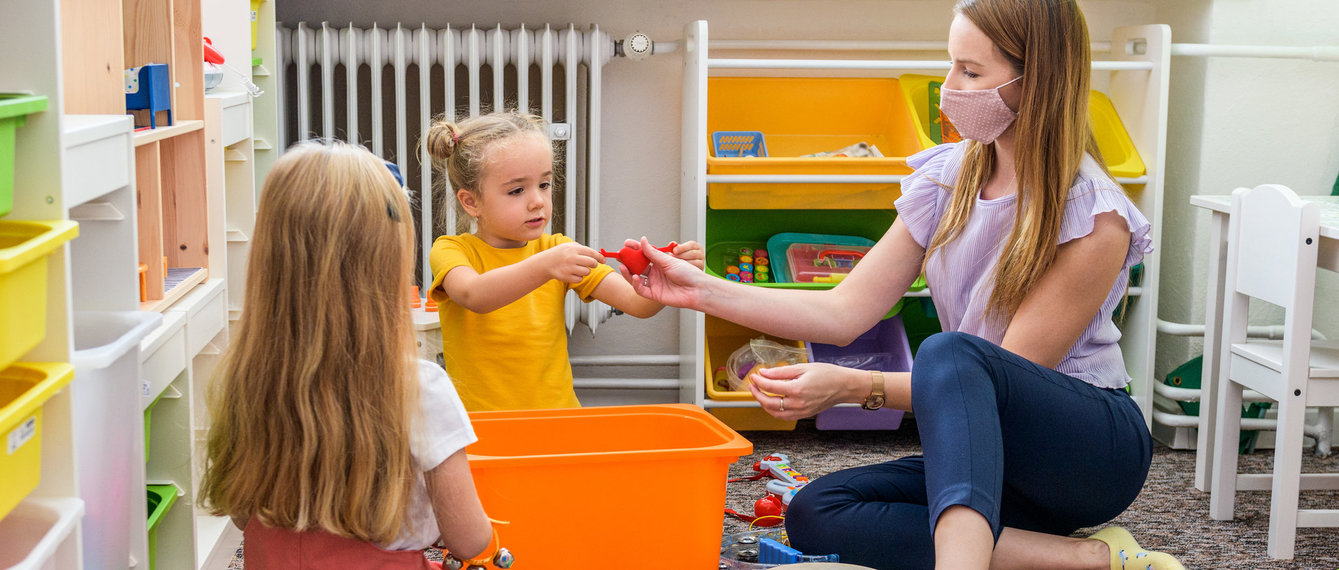 Pädagogin spielt mit Kindergartenkindern