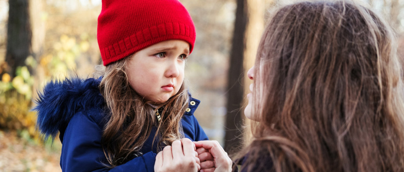 Mutter hält Hände mit ängstlicher Tochter