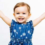 Kinder stärken – Selbstwert, Selbstliebe & Selbstvertrauen © istock Mädchen im blauen Kleid streckt lachend beide Hände in die Höhe