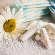 Tampons mit Binden neben einer Blume