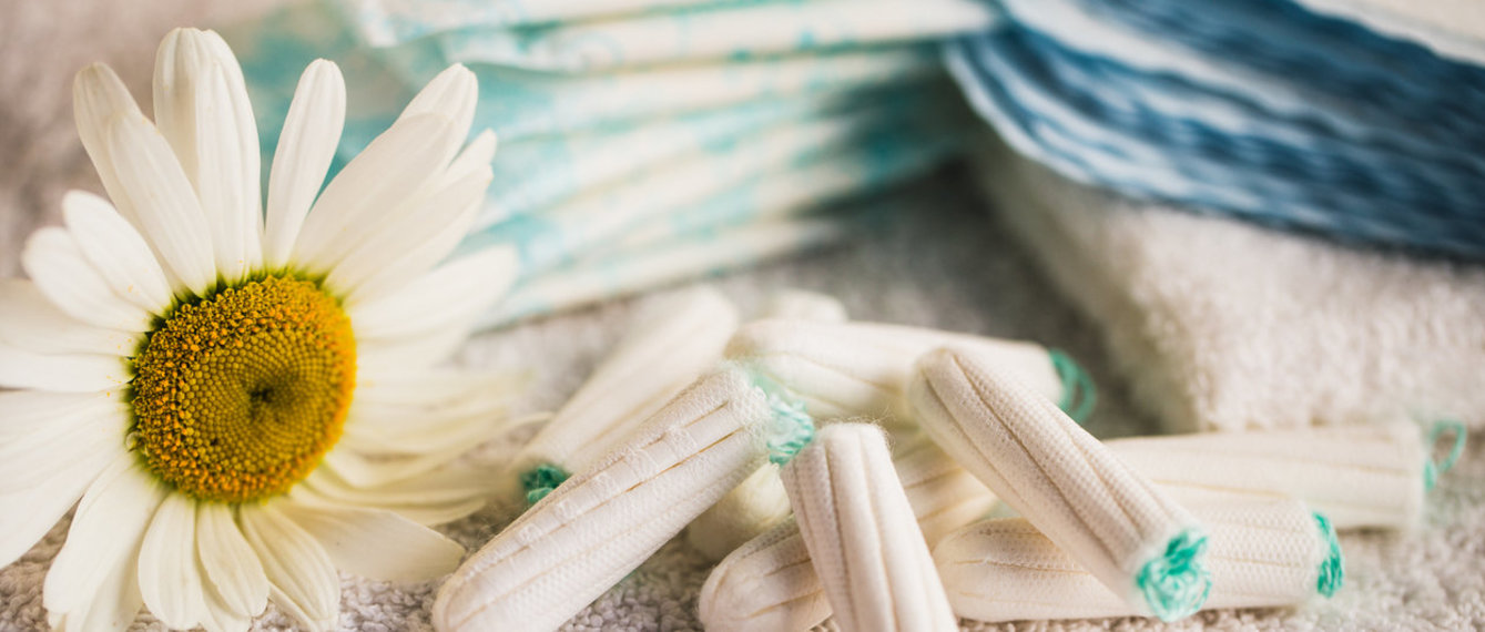 Tampons mit Binden neben einer Blume