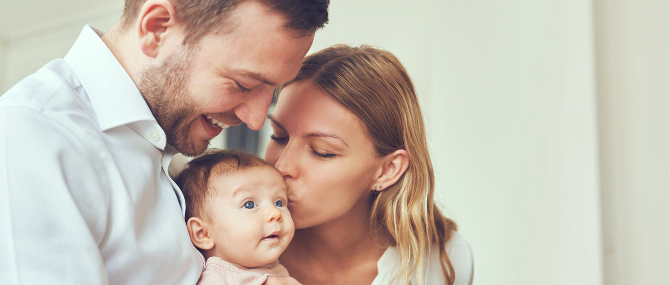 mutter und vater küssen baby auf den kopf