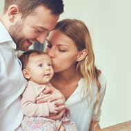 mutter und vater küssen baby auf den kopf