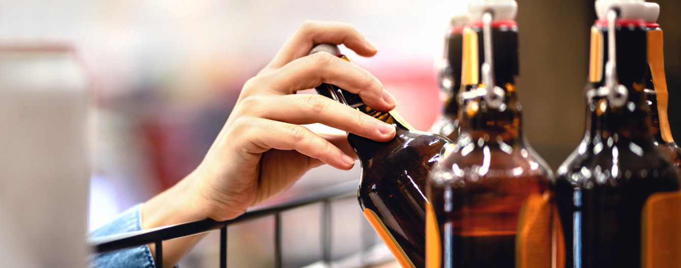 Bierflasche wird aus dem Regal genommen