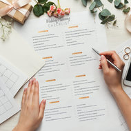 Hochzeitsplanung Checkliste - meinefamilie.at  Hände füllen Hochzeitsplanung auf Papier aus, Handy liegt daneben