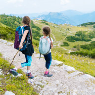 zwei Kinder wandern auf der Alm 