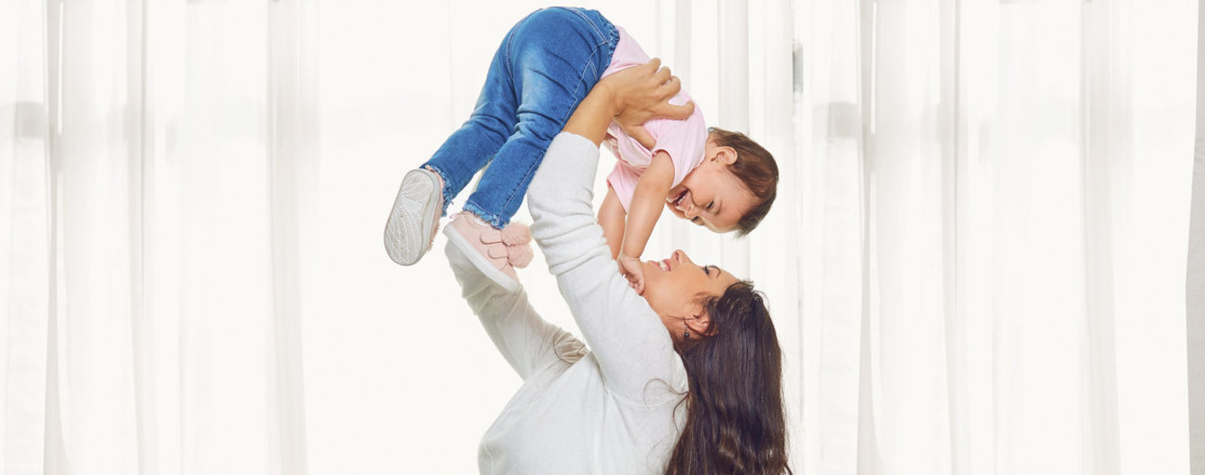 10 Gedanken, wie man ein Kind lieben soll - meinefamilie.at Mutter hält Tochter in die Höhe