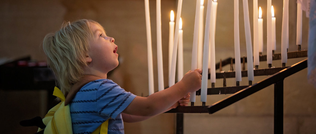 Kleinkind bei den Kerzen in der Kirche