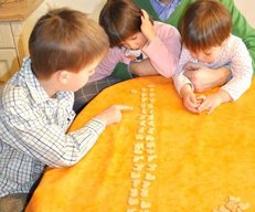 Kinder und Mann spielen am Tisch