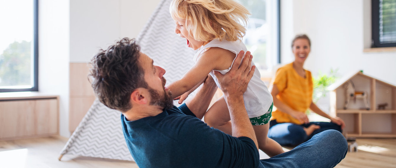 Papa blödelt mit Tochter am Boden herum