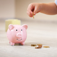 Kind gibt Geld in Sparschwein