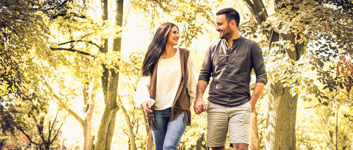 Paar geht Hand in Hand im Wald spazieren