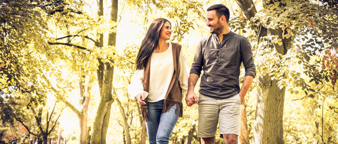 Paar geht Hand in Hand im Wald spazieren