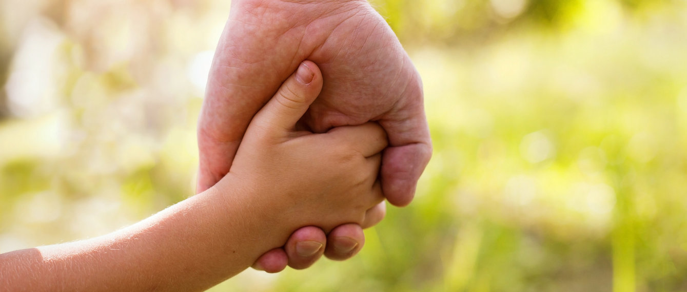 Vater hält Kinderhand