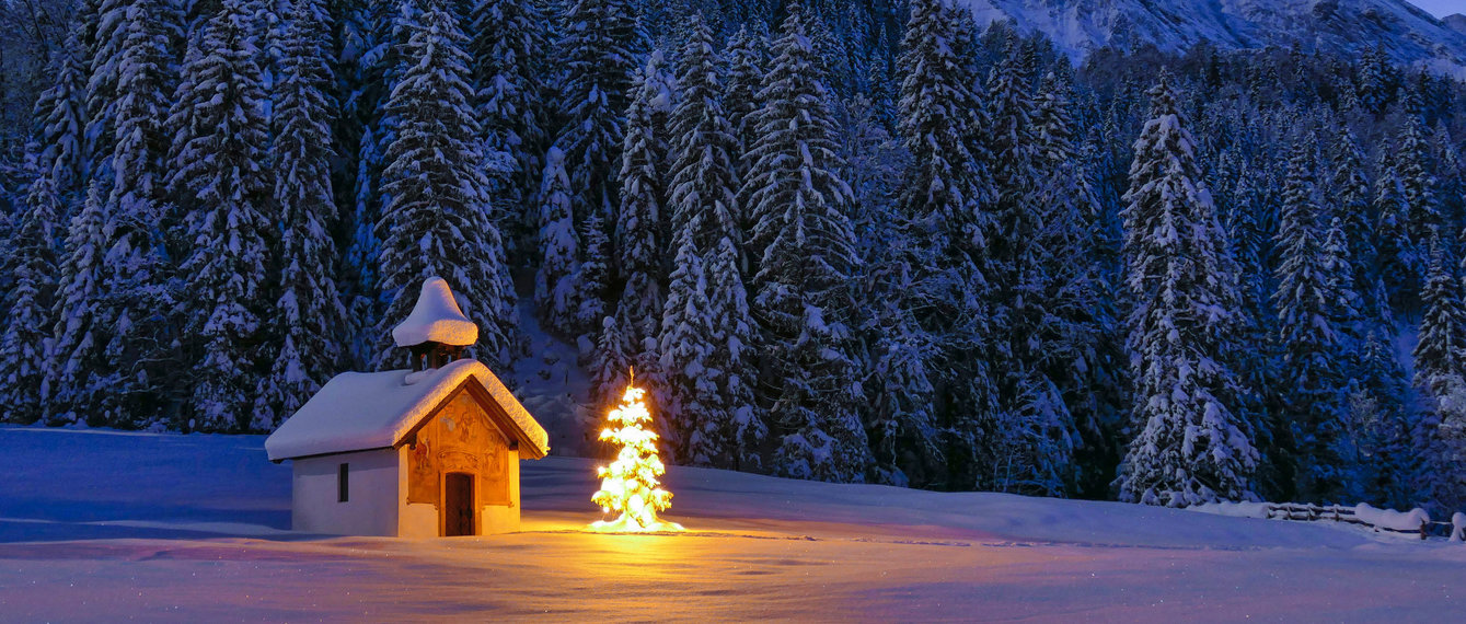 Kapelle im Dunkeln mit beleuchtetem Christbaum