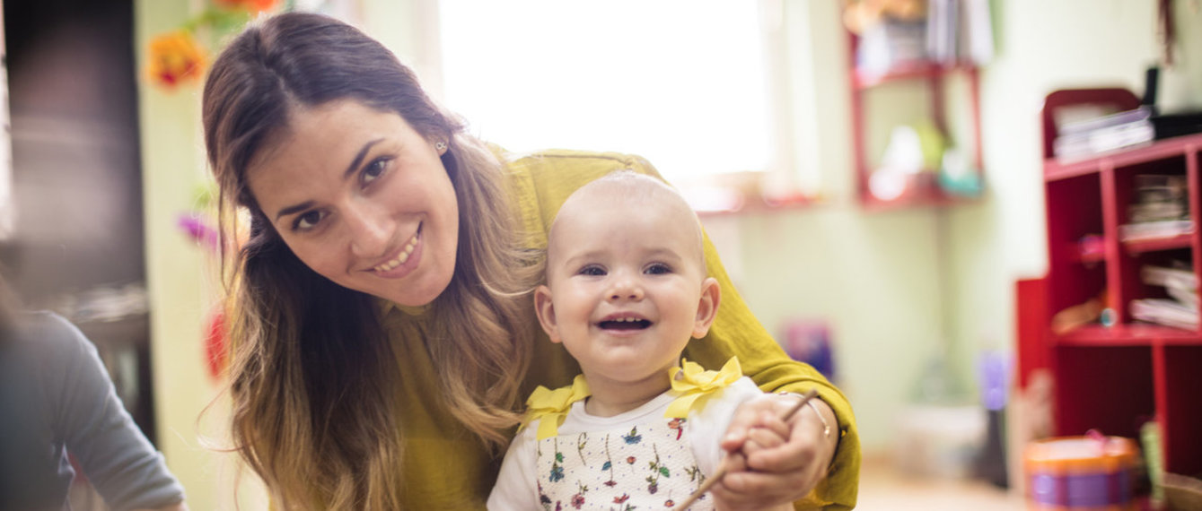 Kindergärtnerin mit kleinem Mädchen