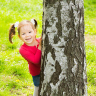 Mädchen hinter Baum