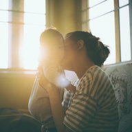 Mutter küsst Baby auf die Wange