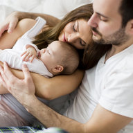 Mutter, Vater und Kind kuscheln