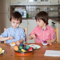 Geschwister färben Ostereier