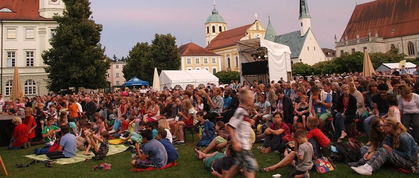 Viele Menschen auf der Wiese vor der Kirche beim Glaubensfestival Altötting