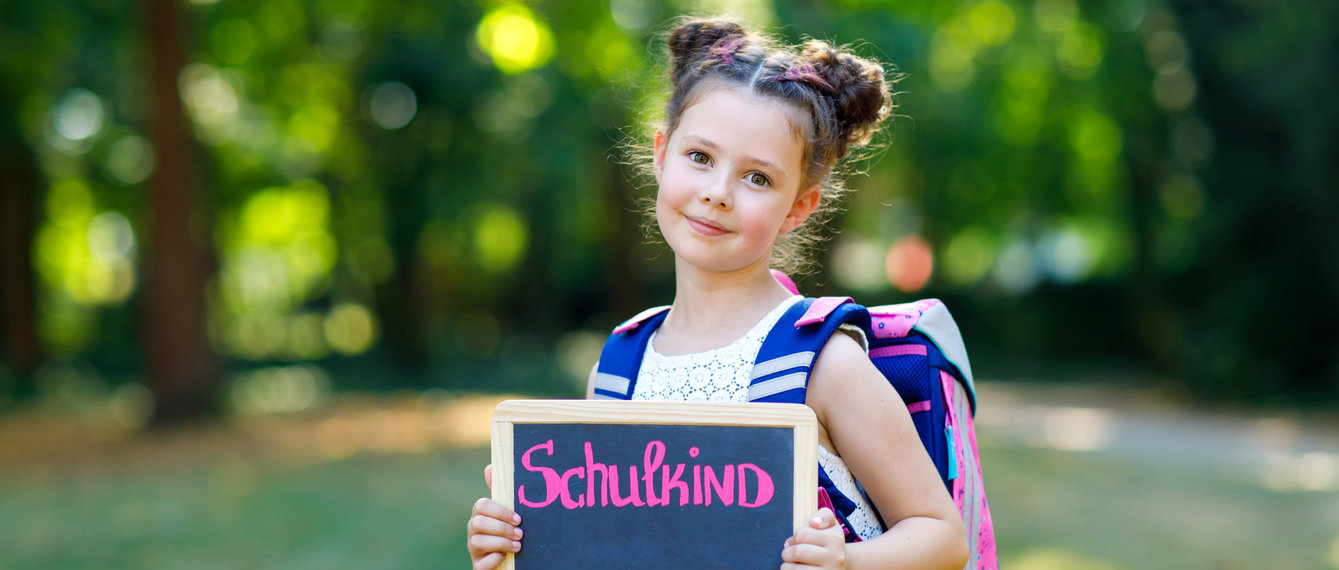 Mädchen beim Schulstart mit Schultasche