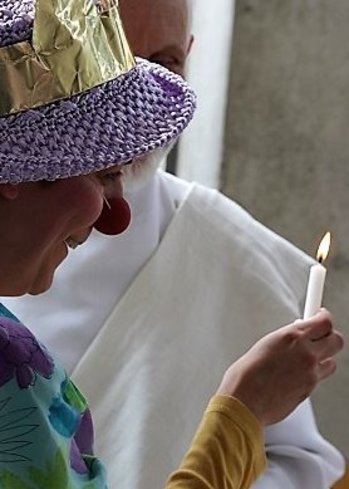 Was hat eine Clownin in der Fastenzeit verloren? © Roman Drbusek Frau als Clown verkleidet hält Kerze