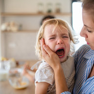 kleines mädchen weint auf dem arm der mutter