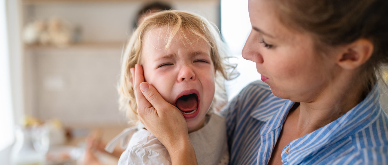 kleines mädchen weint auf dem arm der mutter