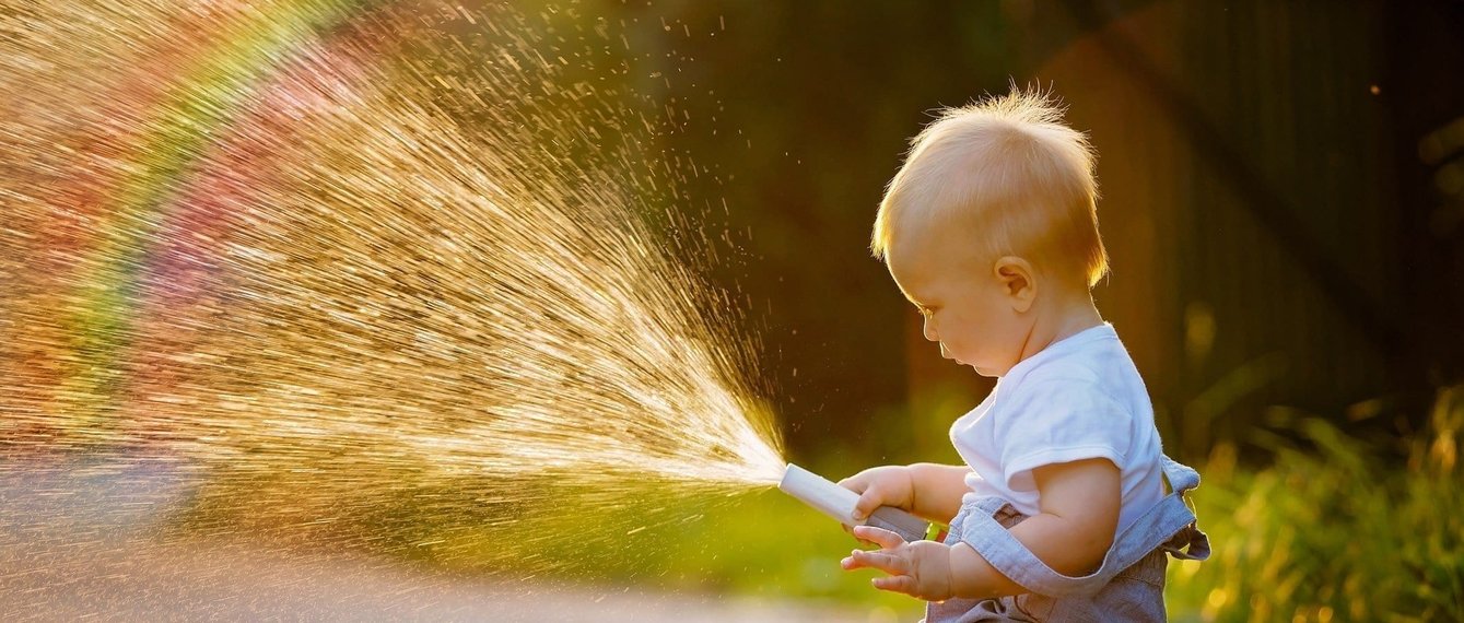 Junge mit Wasserschlauch