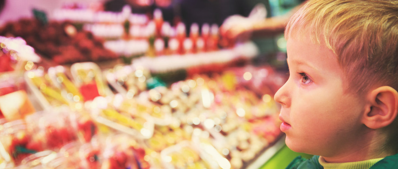 Bub vor der Wursttheke im Supermarkt