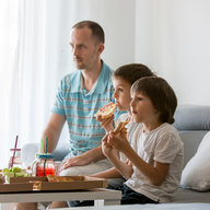Kinder und Vater essen vor Fernseher