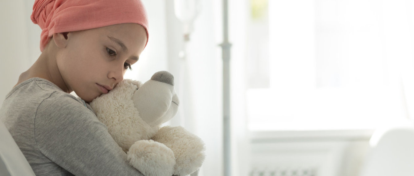 Krebskrankes Mädchen mit Teddy