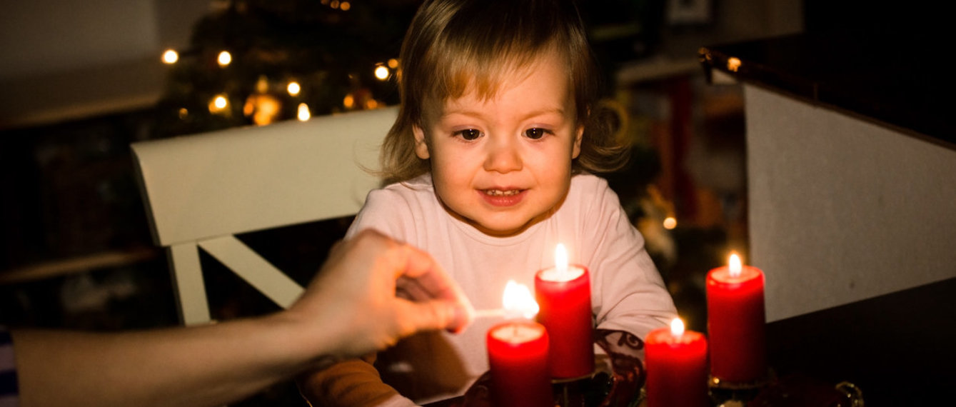 Mädchen das einen Adventkranz anlächelt