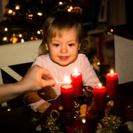 Mädchen das einen Adventkranz anlächelt