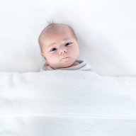 Baby schaut unter der Decke hervor