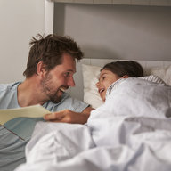 Vater liest Tochter Gutenachtgeschichte vor