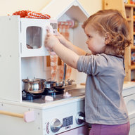 kid playing with toy kitchen