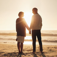 Paar steht am Strand bei Sonnenuntergang