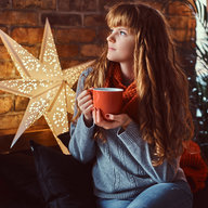 Frau trinkt in Ruhe Tee vor einem Weihnachtsstern