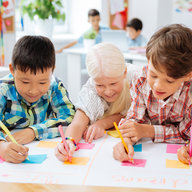 Mehrere Kinder malen an einem Plakat